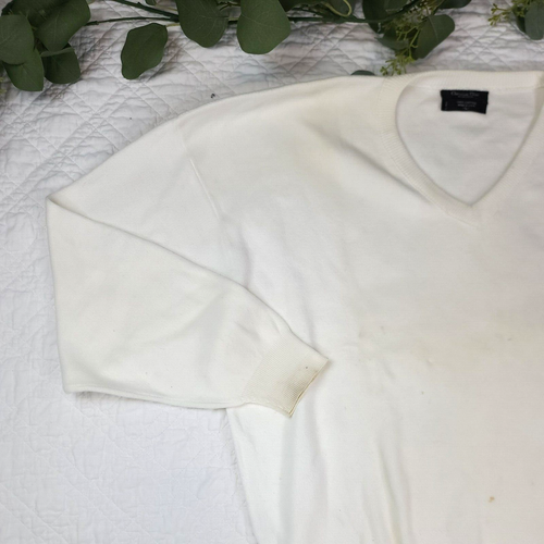 White VTG Christian Dior men’s V-neck sweater made in USA, with short sleeves and crew neckline on fabric surface.