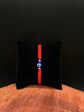 Evil eye blue bracelet made of red thread macrame for protection