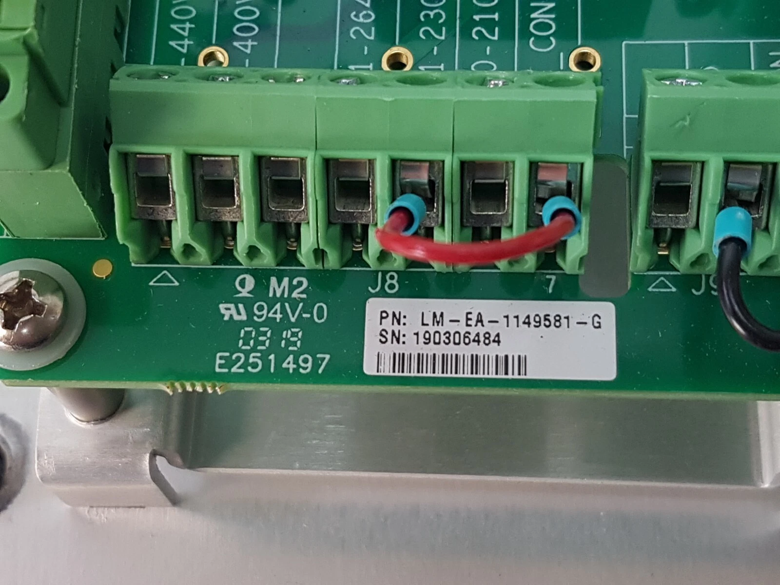 Close-up of the LM-EA-1149581-G label and J8 voltage-selection terminal with a red wire link