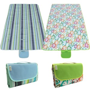 Family sitting on picnic blanket in park giving mature ...