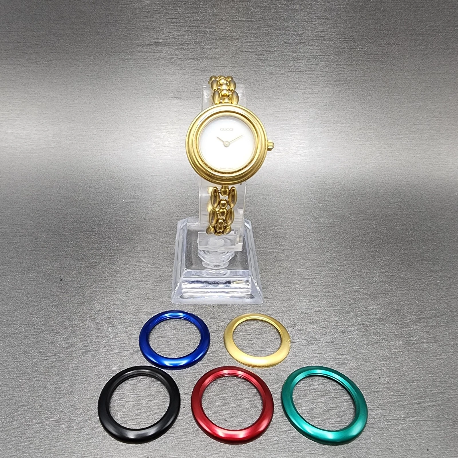 Montre Gucci 11/12 femme 26 mm cadran blanc plaqué or ronde 5 lunettes pile neuve