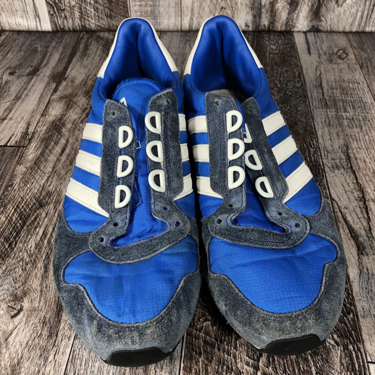 Adidas white shoes with blue stripes top