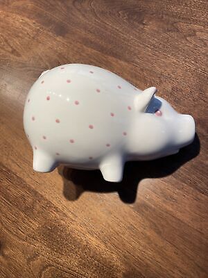 Dot piggy bank in earthenware with pink accents.