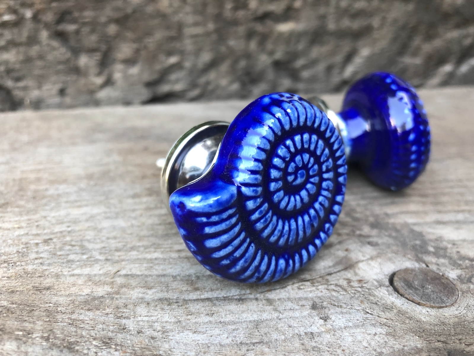 A lovely pair of glazed ceramic Ammonite shaped drawer or cupboard door