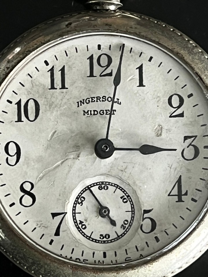 A tiny, running Ingersoll Midget pocket watch with its original paper guarantee — an affordable antique with provenance paperwork still intact.