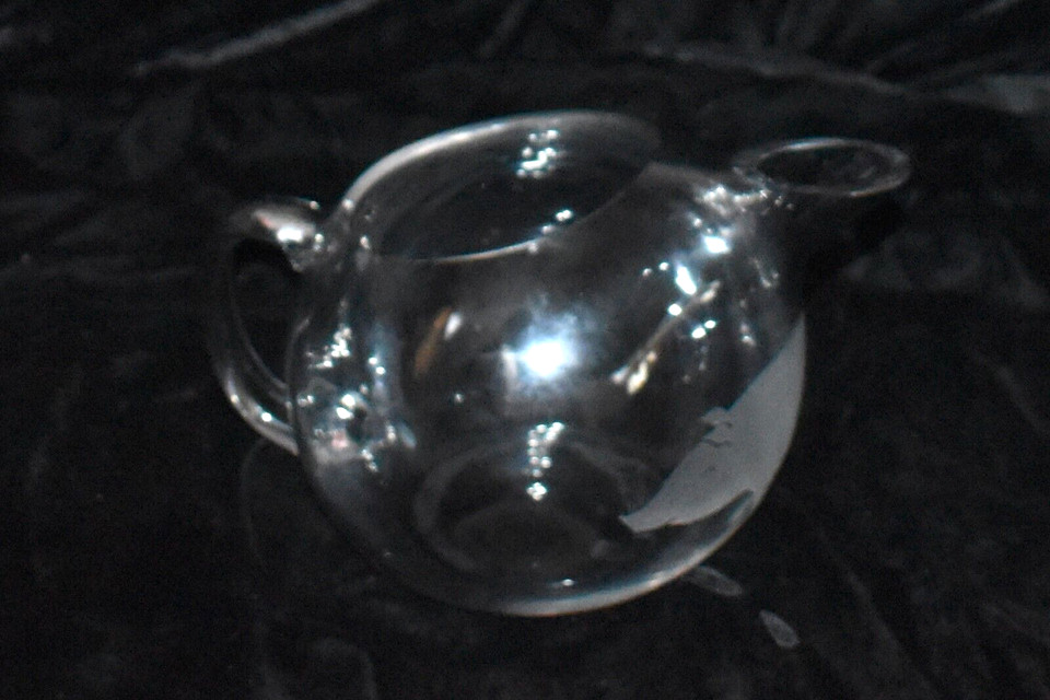 A mid-century etched PIG martini pitcher in clear glass — absurdly specific, visually stunning, and exactly the kind of thing you find once and never again.