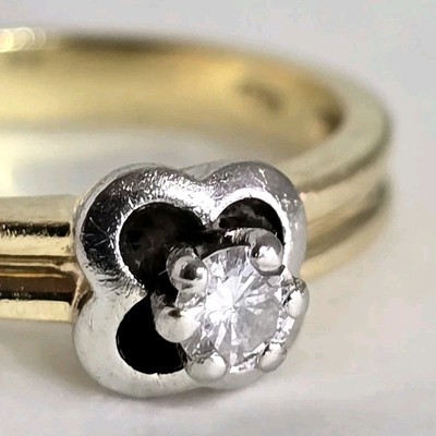 Solitärring 18 kt Gelbgold. In Weißgold mit einem Diamanten im Brillantschliff besetzt 