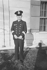 Mann in Uniform steht vor Haus Pilot Postbeamter Lokführer Soldat ? Foto