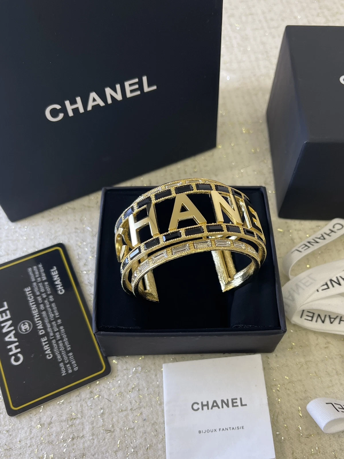 Bracciale CHANEL oro ferramenta design cavo cristallo bianco e nero intarsiato CCS