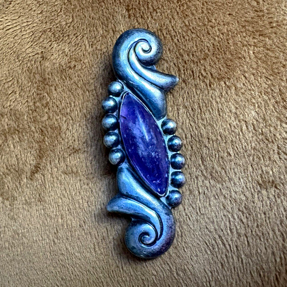 Sterling silver brooch with amethyst stone and ornate scrollwork