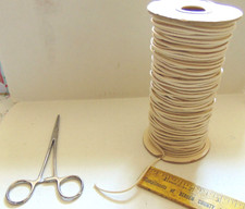 Roll of doll stringing elastic-1/8"-plus clamp.