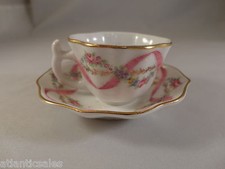 Miniature porcelain cups and saucers with floral design two sets Collectible