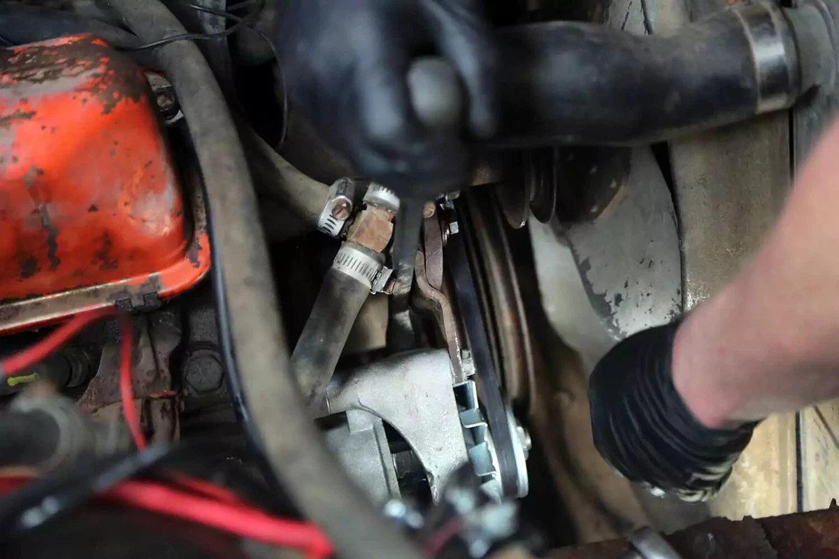 Installing a serpentine belt over the new alternator pulley.