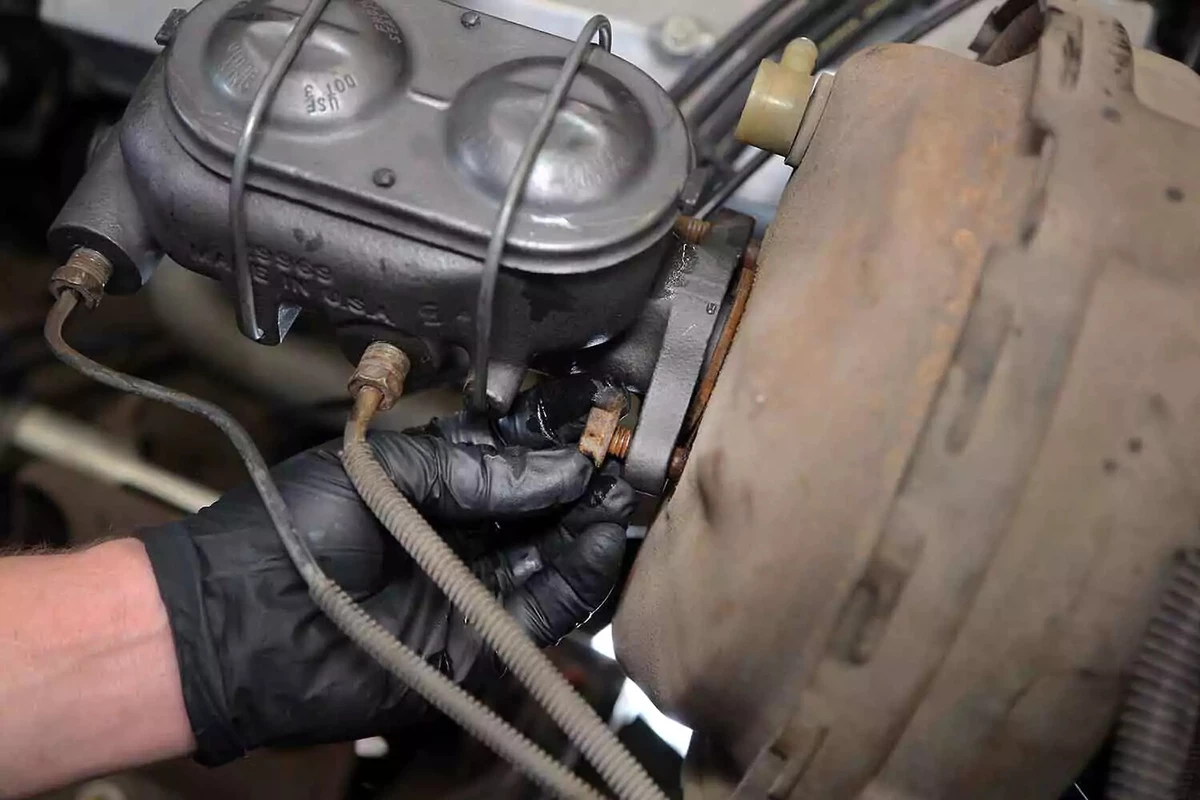 Installing the fasteners onto the brake booster's studs.