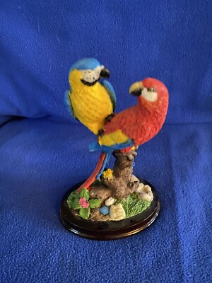Two Colorful Macaw Parrots On A Branch With Flowers On Oval Wooden Base