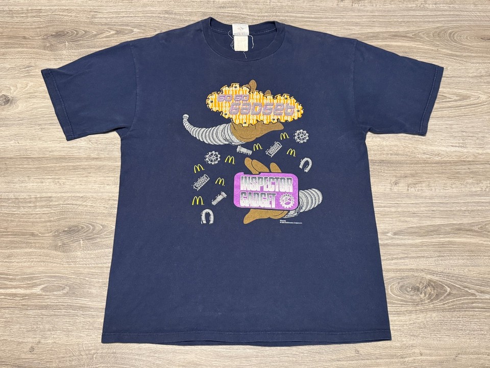 A never-more-relevant piece of 90s nostalgia — an actual promo tee from the 1999 Inspector Gadget McDonald's tie-in, impossibly specific and deeply cool.