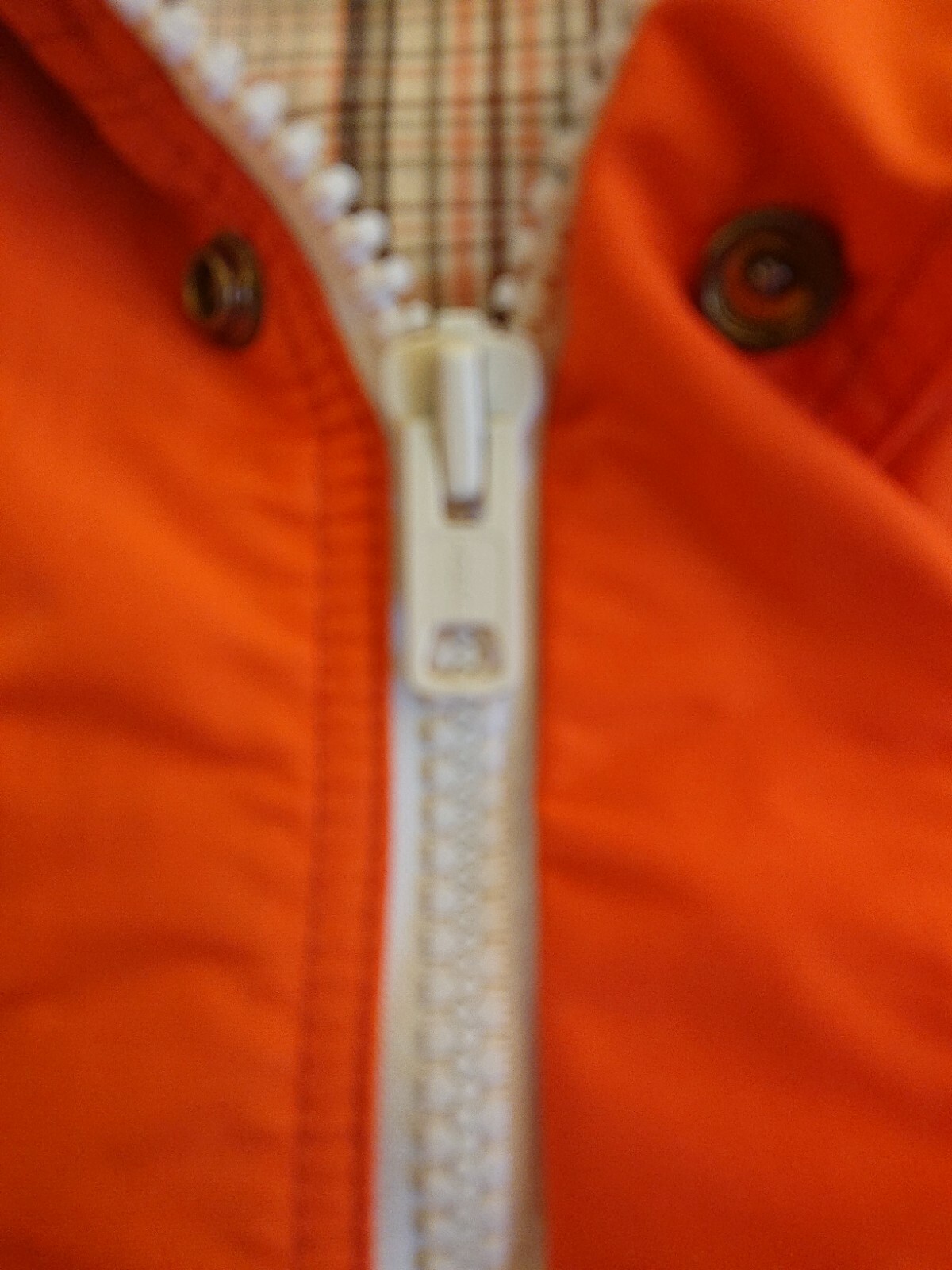 Orange 60/40 cotton nylon vintage parka with white zipper and button front, made in USA.