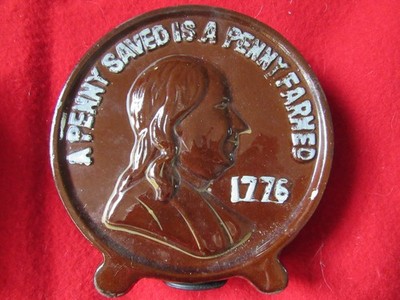 A Penny Saved Is A Penny Earned Brown Bank with bottom insert.