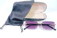 Unisex Rimless Sunglasses With Black And Gold Frames And Maroon Beveled Lenses.