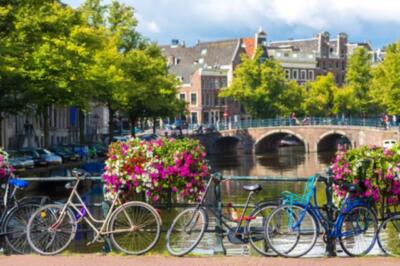 Wandbild: Fahrräder auf einer Brücke über den Kanälen von Amsterdam. [...]