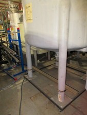 Vertical fiberglass tank on legs, cone bottom. Capacity 1000 gallons.