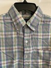 Men’s long-sleeve button-up shirt with purple, green, and yellow plaid pattern and chest pocket, hanging on black hanger.