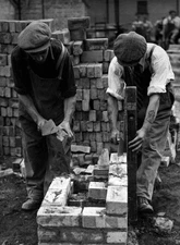 Two workers working to rebuild British capital assemble cinder blo- Old Photo
