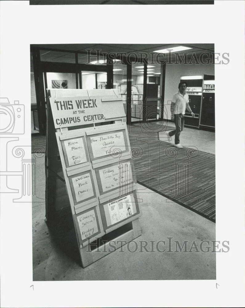 Press Photo Man walks past This Week at the Campus Center sandwich board