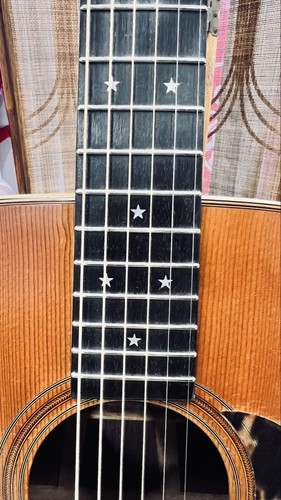 Black Martin D-76 with silver stars on f-holes, gold hardware, and dark wood fretboard with white inlay.