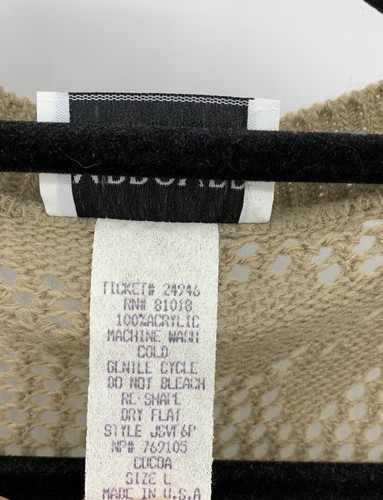 Beige open-front sweater vest with lace pattern, featuring white fabric tag with black text reading “Made in U.S.A.”