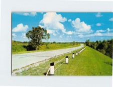 Postcard Road  Curving Road with Guardrail in a Grassy Landscape under Clouds