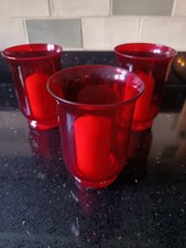 3 Red Glass Candle Holders With Candles.