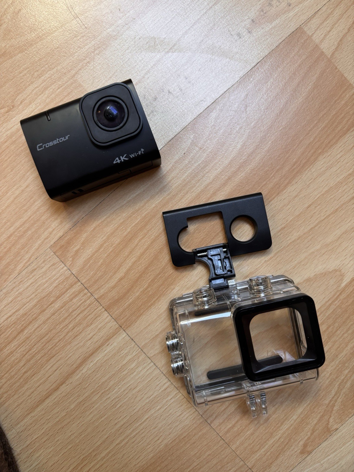 Caméra style GoPro avec accessoires incluant un objectif grand angle et un boîtier étanche noir
