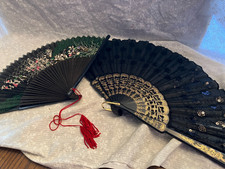 2 black folding hand fans. 8 inch flower one is black wood with sheer fabric. 9