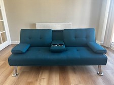 Blue two seater convertible sofa bed with cup holders in the middle