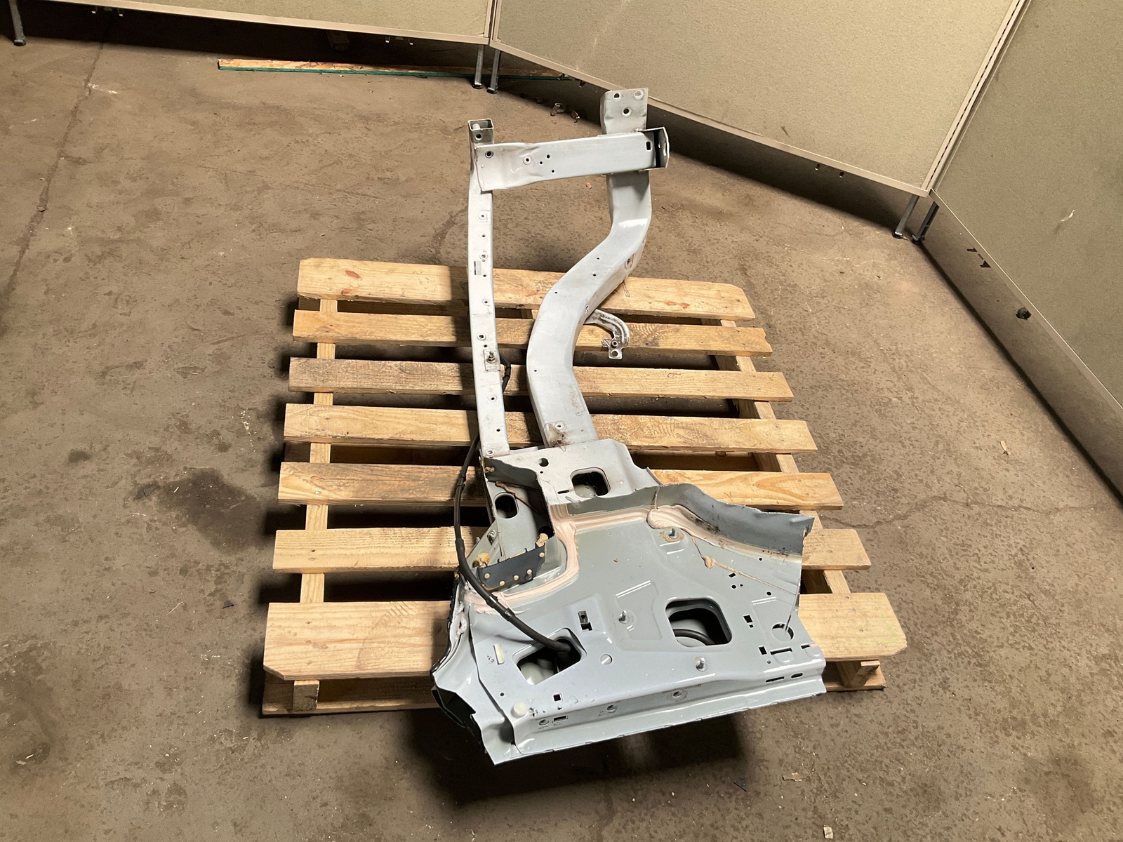 Silver 13-18 RAM 1500 front left driver frame apron radiator support with bent-up design on worn concrete floor.
