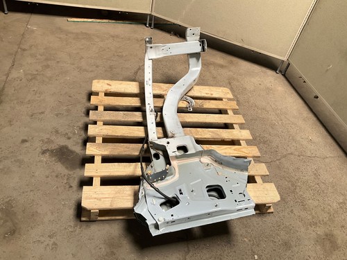 Silver 13-18 RAM 1500 front left driver frame apron radiator support with bent-up design on worn concrete floor.