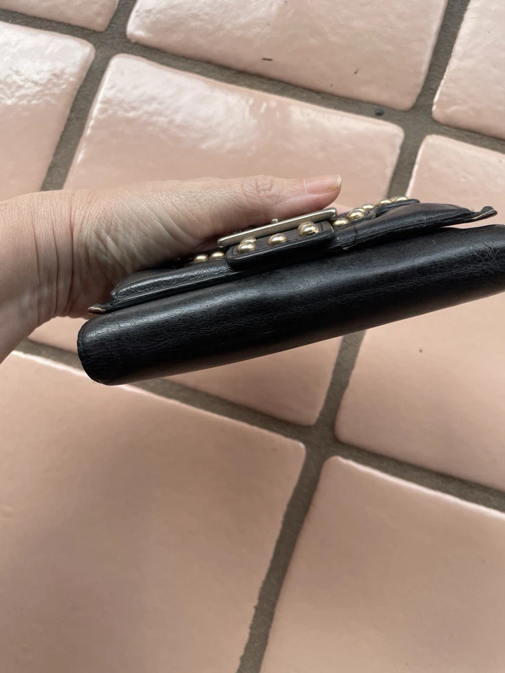 Cartera sin asas Isabella Fiore de cuero negra con tachuelas doradas triple pliegue Foto 3 de 4