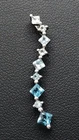 Sterling Silver Descending Blue Aquamarine / Topaz CZ Curved Swirl Long Pendant