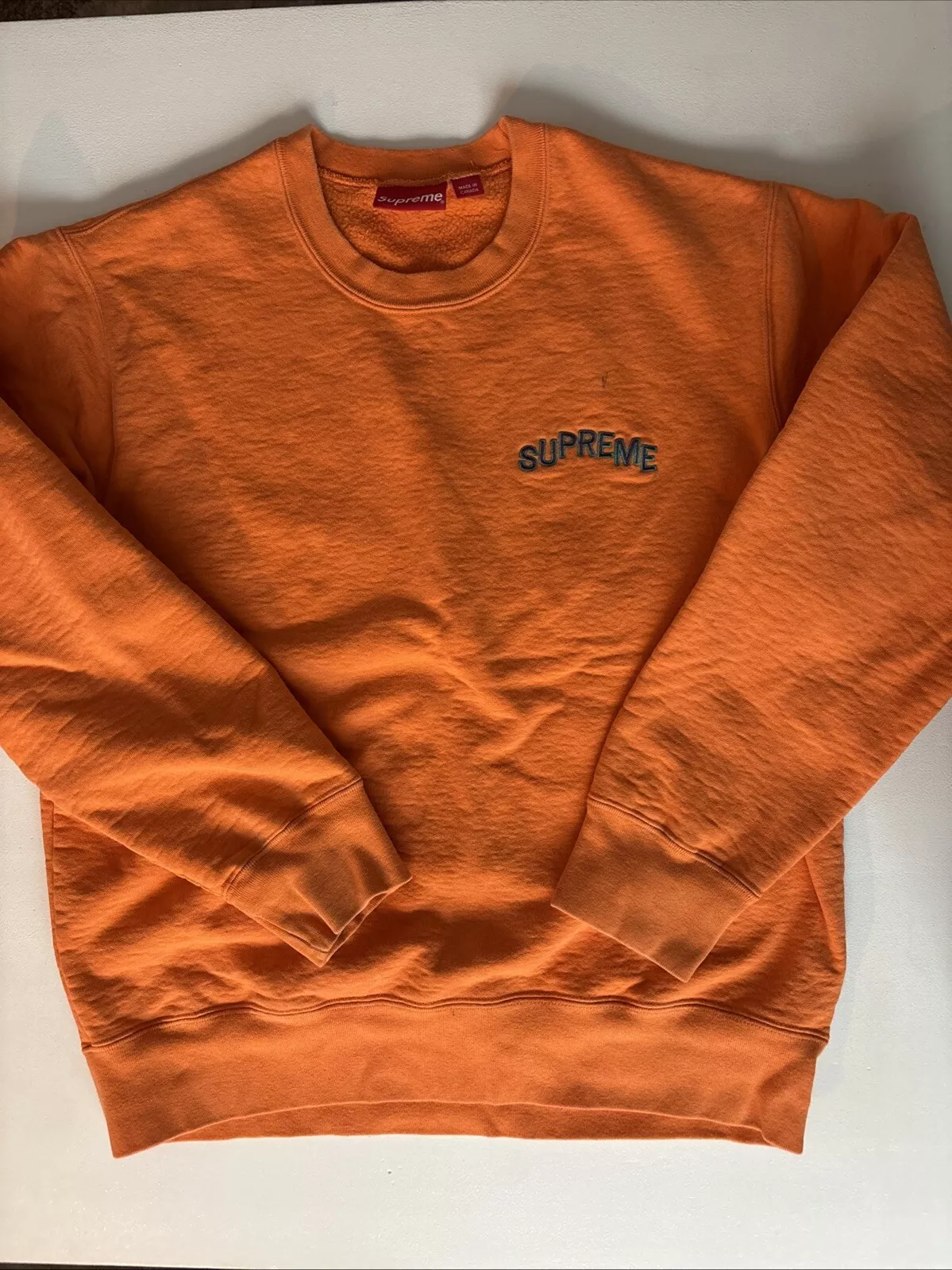 Sweat Supreme Orange Large   Petite marque stylo près du logo et des taches sur le devant