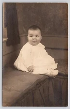 Real Photo Postcard Chubby Cheeked Baby Sitting On Cushion in Studio c1910 RPPC