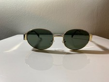 Unisex, gold framed sunglasses with oval shaped green lenses