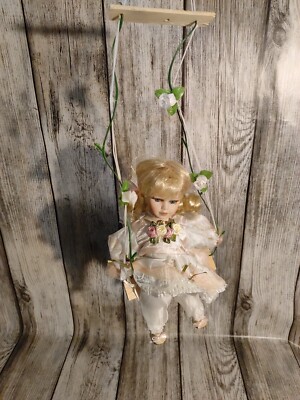Vintage poupée de porcelaine sur une balançoire Photo Stock