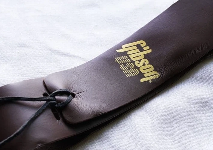 Rara correa de guitarra de cuero Gibson de los años 90 logotipo dorado marrón stock muerto de colección de Ja Foto 2 de 4