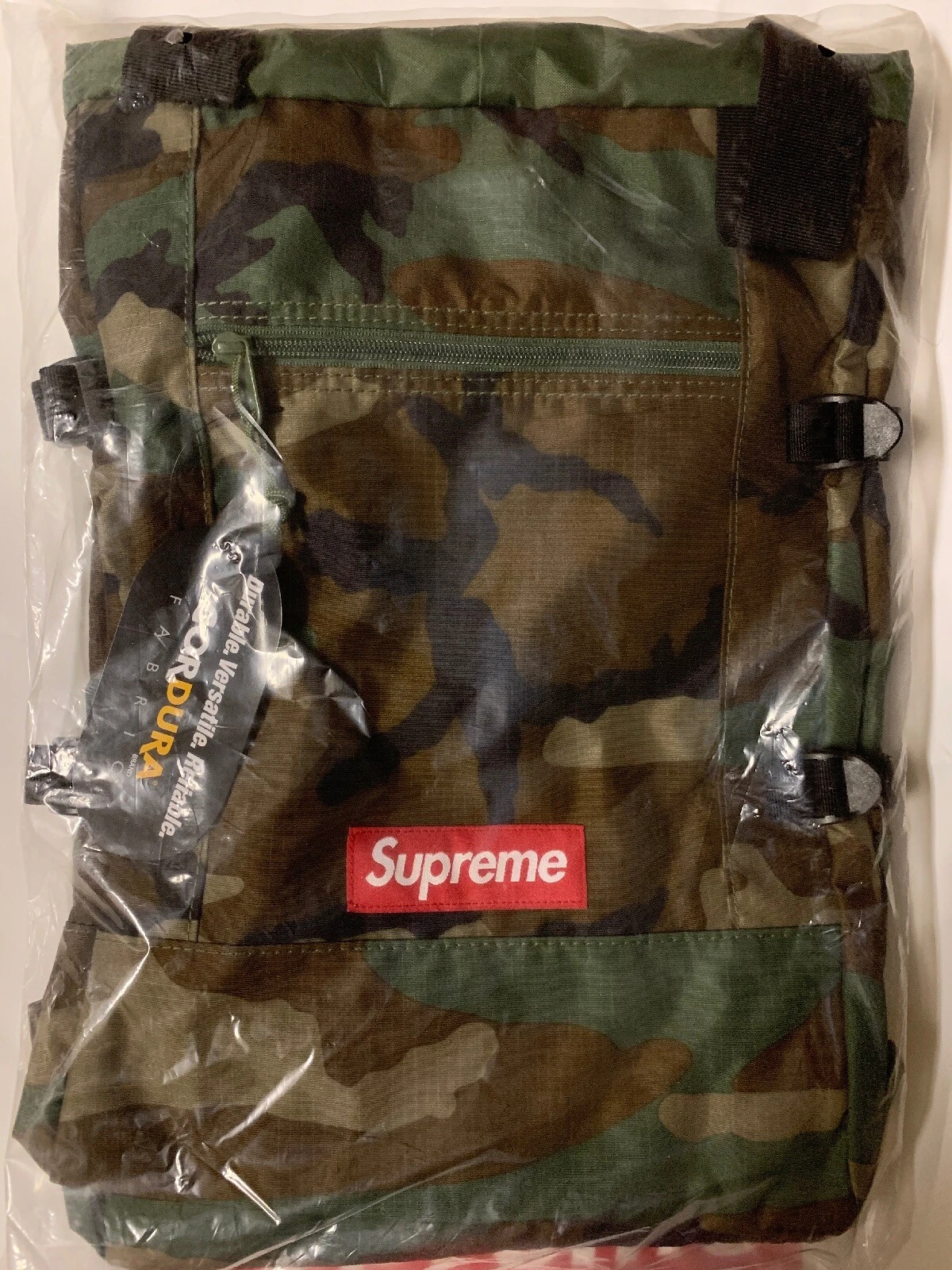 SAC À DOS SUPREME FOURRE TOUT WOODLAND CAMO SS19 CORDURA ROUGE ROYAL BOÎTE NOIRE LOGO CDG