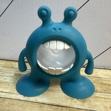 Blue plastic monster toothbrush toothpaste holder with suction cup feet