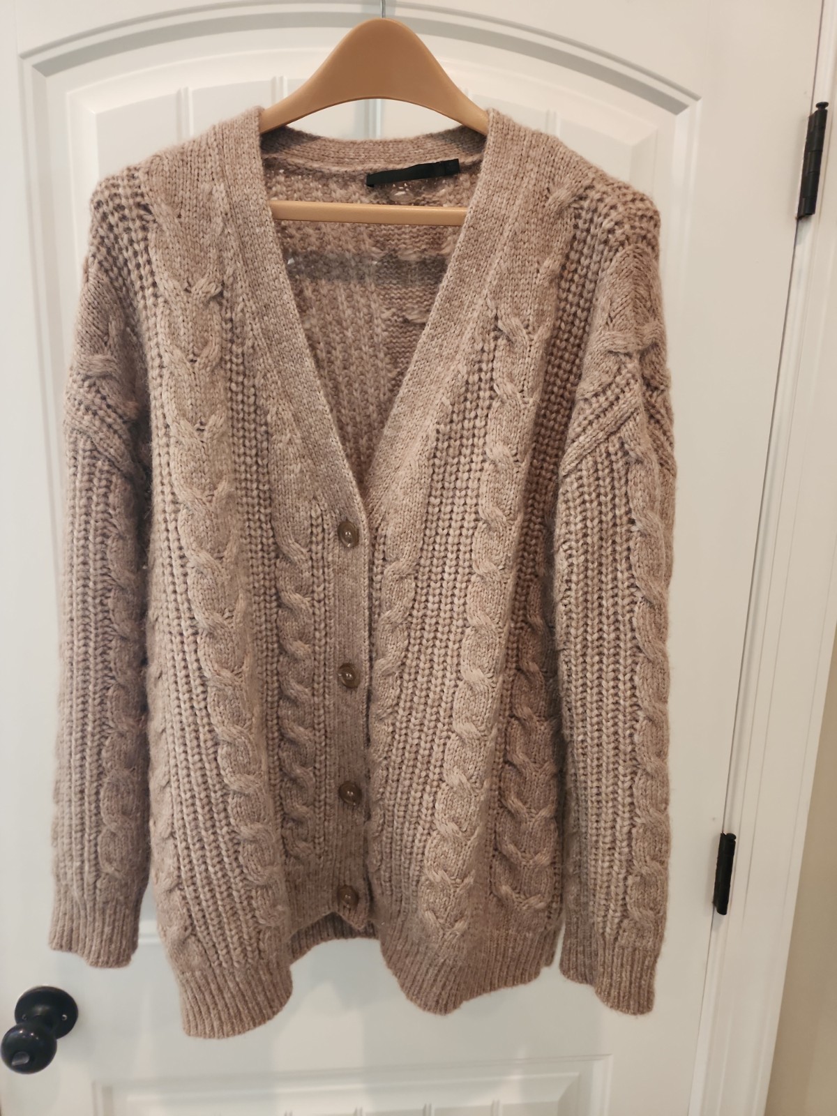 Taupe cropped chunky knit cocoon cardigan with wood toggle buttons, shown worn over jeans.