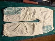 White pants with blue patterned patches