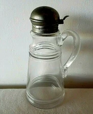 ANTIQUE CIRCA 1920'S RIBBED GLASS SYRUP PITCHER WITH THE ORIGINAL TIN FLIP TOP