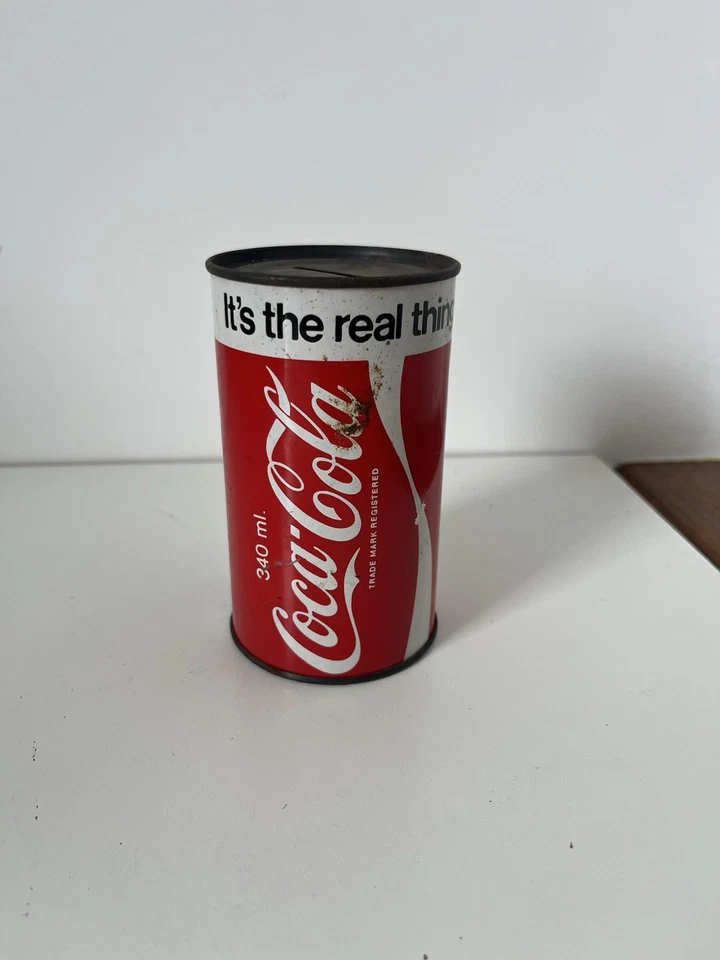 Tirelire Vintage Coca-Cola en Tôle 1970 – It's The Real Thing 11,5 cm - Photo 1/4